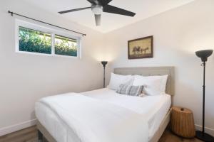 1 dormitorio con 1 cama blanca y ventilador de techo en Bichito’s Playground - Heated pool, Walkable, en Phoenix