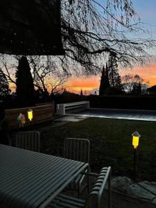 einen Tisch und Stühle in einem Hof mit Sonnenuntergang in der Unterkunft Grande villa avec piscine in Neuenburg