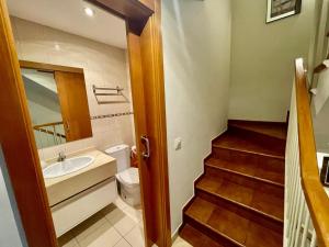 uma casa de banho com um lavatório, um WC e uma escada. em Tenerifeopenhome Townhouse Oasis Fañabe 21 em Adeje