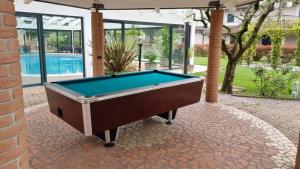 einen Billardtisch auf einer Terrasse mit Pool in der Unterkunft Room for rent Castelnuovo in Castelnuovo del Garda