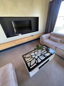 a living room with a tv and a couch and a table at Luxury Rooftop Vlora in Vlorë