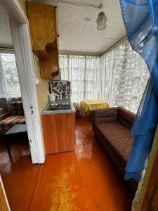 a living room with a couch and a kitchen at Vasaras mājiņa pie Rāznas ezera Nr 6 in Ragi