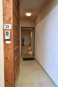 a hallway with a door with a sign on it at API Tenna Apartaments Betulla 2 in Tenna 