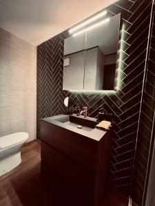 a bathroom with a sink and a toilet and a mirror at Garden Street Lommel - The Green Haven in Lommel +14 photos