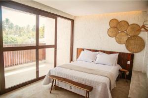 a bedroom with a bed and a large window at Casa Pitanga - 150 mts do mar in Pôrto de Pedras