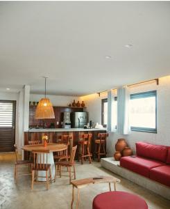 a living room with a red couch and a table at Casa Pitanga - 150 mts do mar in Pôrto de Pedras