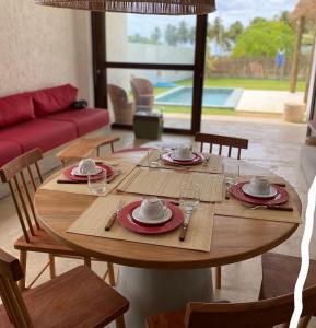 a wooden table with plates and cups on top of it at Casa Pitanga - 150 mts do mar in Pôrto de Pedras +22 photos