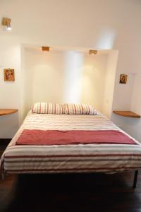 1 dormitorio con 1 cama con manta a rayas en Trullo d'Itria, en Locorotondo
