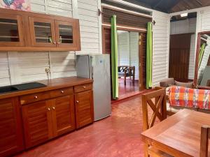 Il comprend une cuisine équipée d'un réfrigérateur et un salon avec une table. dans l'établissement Maison meublée « valiha », à Hell-Ville