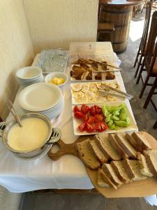 una mesa con sándwiches y pan y un tazón de sopa en Guesthouse Marku - Mrizi i Zanave, en Fishtë