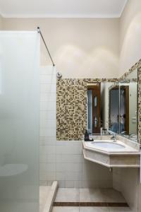 ein Bad mit einem Waschbecken und einem Spiegel in der Unterkunft Livingville The Two-Fifty in Kairo