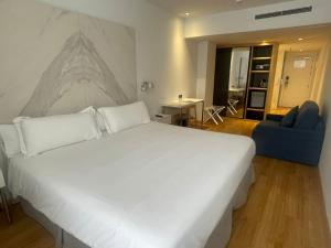 sypialnia z dużym białym łóżkiem z rysunkiem na ścianie w obiekcie Talayot - Adults Only w Cala Millor