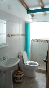 ein weißes Badezimmer mit einem Waschbecken, einem WC und einem Waschbecken in der Unterkunft Casaione in Puerto Colombia