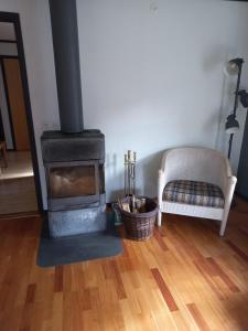 a fireplace in a living room with a couch and a chair at Vakantiewoning in Småland Zuid-Zweden in Hjältevad