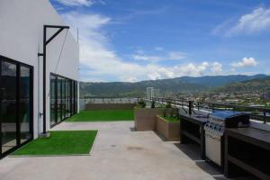 a balcony with a grill and a view of a city at Skyline Serenity: Luxury Retreat in Tegucigalpa in Tegucigalpa