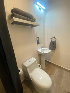 a bathroom with a white toilet and a sink at Skyline Serenity: Luxury Retreat in Tegucigalpa in Tegucigalpa