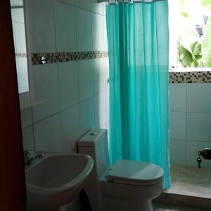 Puerto Colombia的住宿－Casaione，浴室设有卫生间和蓝色的浴帘。