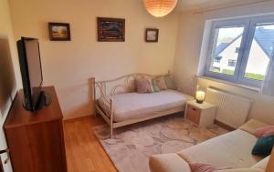 a small living room with a couch and a tv at Dom Wakacyjny U BARBASI - 7 DNI W DOBREJ CENIE ! in Chmielno