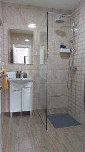 y baño con ducha y lavamanos. en Gold Apartments, en Skradin