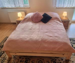 a bed in a bedroom with two lamps on tables at Dom Wakacyjny U BARBASI - 7 DNI W DOBREJ CENIE ! in Chmielno