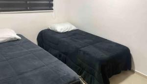 twee bedden naast elkaar in een kamer bij Apartamento aconchegante perto do Shopping Iguatemi in Votorantim