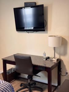 a desk with a chair and a television on a wall at The Lodge Tulelake in Tulelake +9 photos