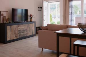 Una sala de estar con un sofá y un televisor de pantalla plana. en Modernes, stilvolles Apartment, en Albstadt