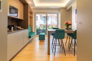 een keuken met een tafel en groene stoelen bij Pescara Inn Luxury Suites in Pescara