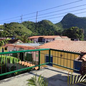 ein gelbes und grünes Gebäude mit Bergen im Hintergrund in der Unterkunft Casaione in Puerto Colombia