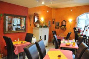 a restaurant with tables and chairs and a mirror at Hotel Le Luxembourg in La-Roche-en-Ardenne