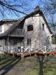 a large stone house with a porch and a balcony at Hot Spring Resort Usui Pass Forest Park "Natural H - Vacation STAY 60419v in Karuizawa