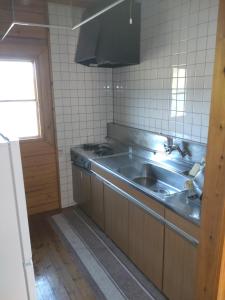 a kitchen with a stainless steel sink and a window at Hot Spring Resort Usui Pass Forest Park "Natural H - Vacation STAY 60419v in Karuizawa