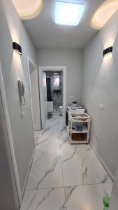 a bathroom with white walls and a phone on the wall at Dei Cozy Apartment in Shkodër