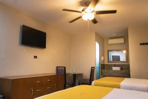 a hotel room with two beds and a flat screen tv at Hotel Maioris El Diez Culiacan in Culiacán