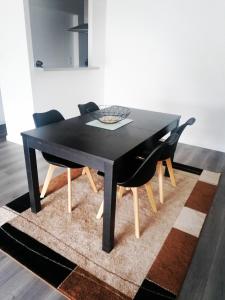 a black dining room table with two black chairs at Détente sur l huisne in Le Mans