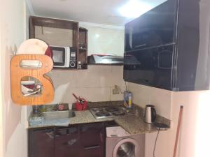 a small kitchen with a sink and a microwave at Porto marina in El Alamein