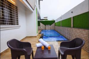a swimming pool with two chairs and a table at LAUGHTALE VILLA 4Bhk Swimming Pool in Lonavala