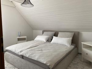 ein Bett mit zwei Kissen darauf in einem Schlafzimmer in der Unterkunft Amazing apartment in Baden-Württemberg in Owingen