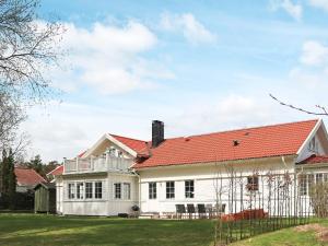 uma casa branca com um telhado vermelho em Holiday home Halmstad XII em Halmstad