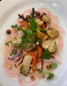 a white plate of food with vegetables on it at Panoramahotel Steirerland in Kitzeck im Sausal