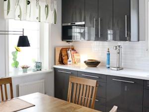 a kitchen with black cabinets and a wooden table at Holiday home Halmstad XII in Halmstad