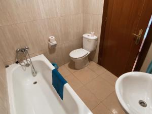 a bathroom with a toilet and a tub and a sink at Pensión Torrecárdenas in Almería