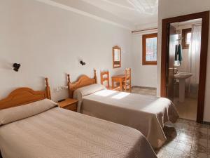 a hotel room with two beds and a bathroom at Pensión Torrecárdenas in Almería