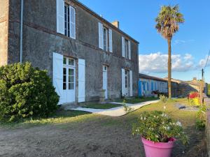 ein Gebäude mit einer Palme davor in der Unterkunft Le Colibri - Domaine de la Houblette in Challans