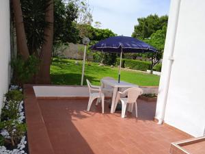 a table and chairs with an umbrella on a patio at Casa Scottodiuccio in Procida +5 photos
