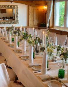 una mesa larga con velas blancas y sillas blancas en Panoramahotel Steirerland, en Kitzeck im Sausal