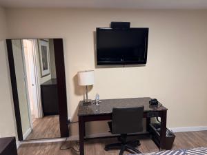 a room with a desk and a television on the wall at The Lodge Tulelake in Tulelake