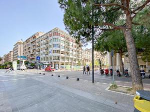 een straat in een stad met gebouwen en een boom bij Pescara Inn Luxury Suites in Pescara