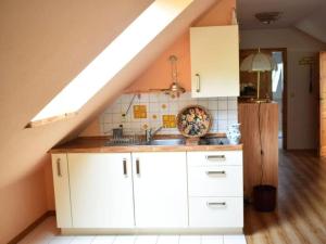 a kitchen with white cabinets and a sink at Beach holiday home directly on the Veluwemeer in Kargow