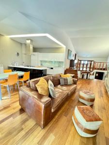 - un salon avec un canapé en cuir brun et une table dans l'établissement Villetta Ginori - Private Spa, à Grosseto